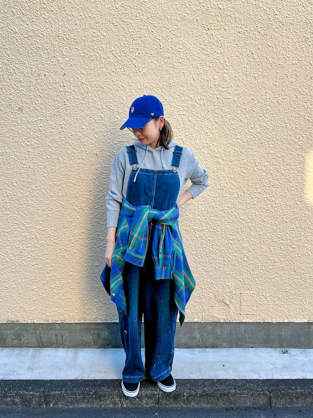 ブルー系のサロペット/オーバーオール、ブラック系のスニーカー、ブルー系のシャツ/ブラウスを着用したレディースの冬コーディネートの2枚目の写真