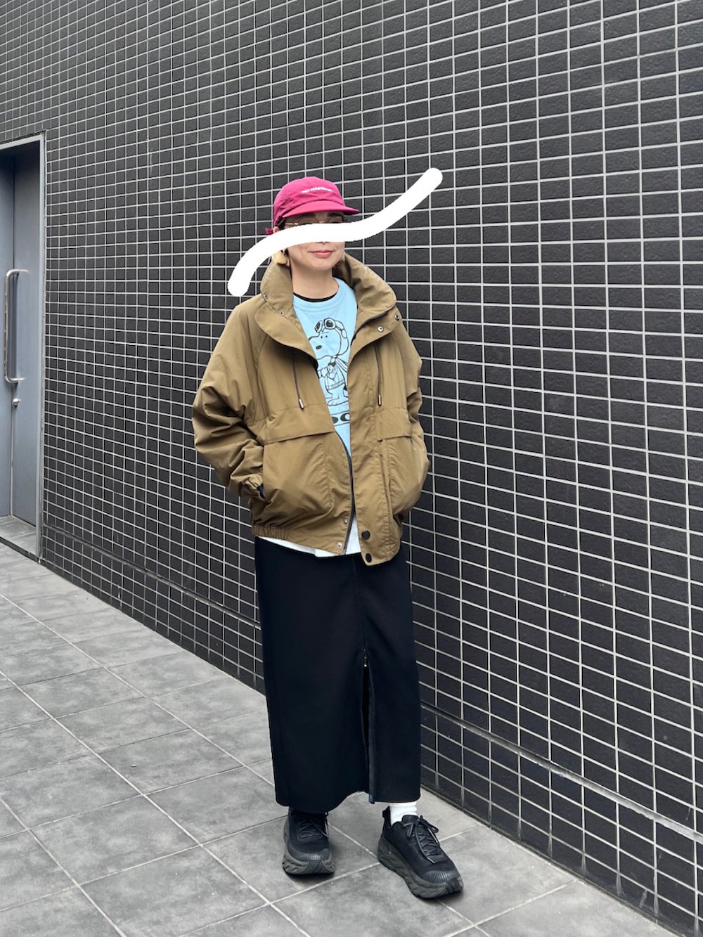 ブラック系のスニーカー、グリーン系のマウンテンパーカー、ブラック系のスカートを着用したレディースの秋コーディネートの2枚目の写真