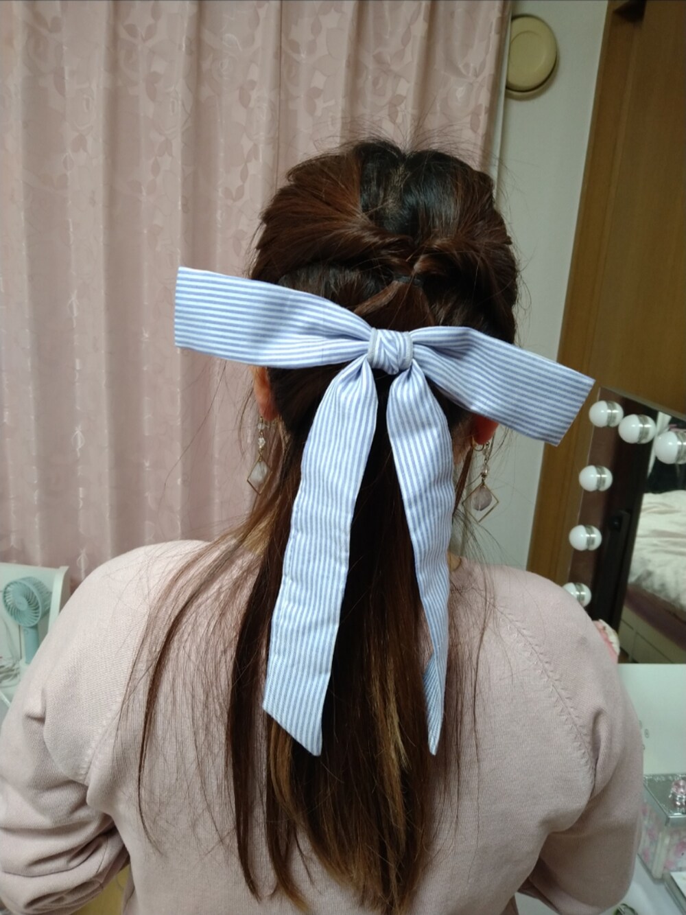 ピンク系のカーディガン/ボレロ、ブルー系のワンピース、ブルー系のバレッタ/ヘアクリップを着用したレディースの春コーディネートの2枚目の写真