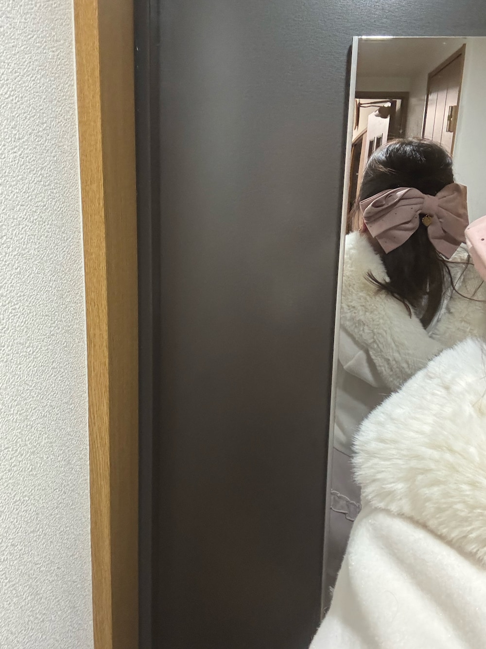 ホワイト系のその他アウター、ピンク系のスカート、ピンク系のハンドバッグを着用したレディースの冬コーディネートの3枚目の写真