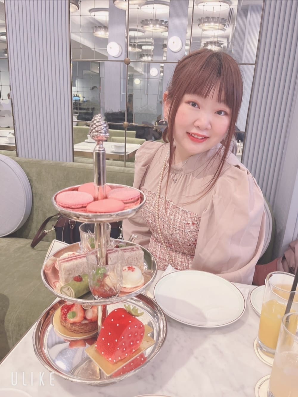 ピンク系のダッフルコート、ピンク系のワンピース、ブルー系のショルダーバッグを着用したレディースの冬コーディネートの2枚目の写真