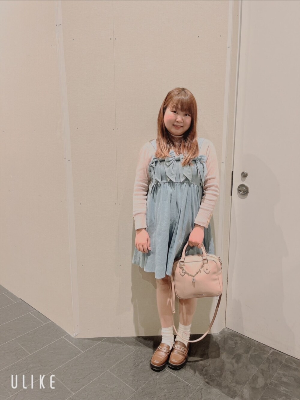 ピンク系のショルダーバッグ、ブラウン系のローファー、ピンク系のテーラードジャケットを着用したレディースの春コーディネートの2枚目の写真