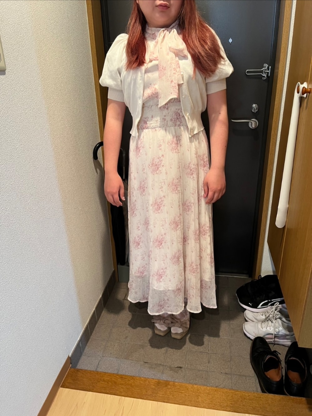 ピンク系のショルダーバッグ、ピンク系のワンピース、ホワイト系のニット/セーターを着用したレディースの春コーディネートの2枚目の写真