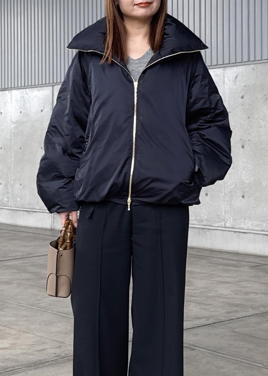 ブルー系のダウンジャケット/コート、グレー系のニット/セーター、ブラック系のその他パンツを着用したレディースの冬コーディネートの6枚目の写真