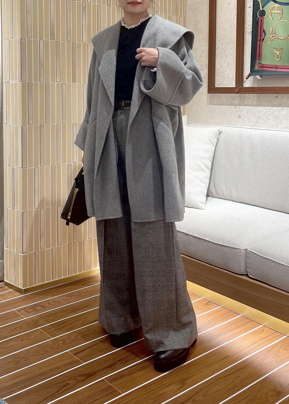 ブラウン系のハンドバッグ、グレー系のその他アウター、ブラック系のブーツを着用したレディースの秋コーディネートの6枚目の写真