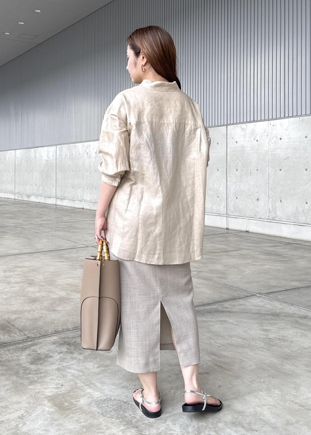 ベージュ系のトートバッグ、シルバー系のサンダル、ベージュ系のシャツ/ブラウスを着用したレディースの秋コーディネートの3枚目の写真