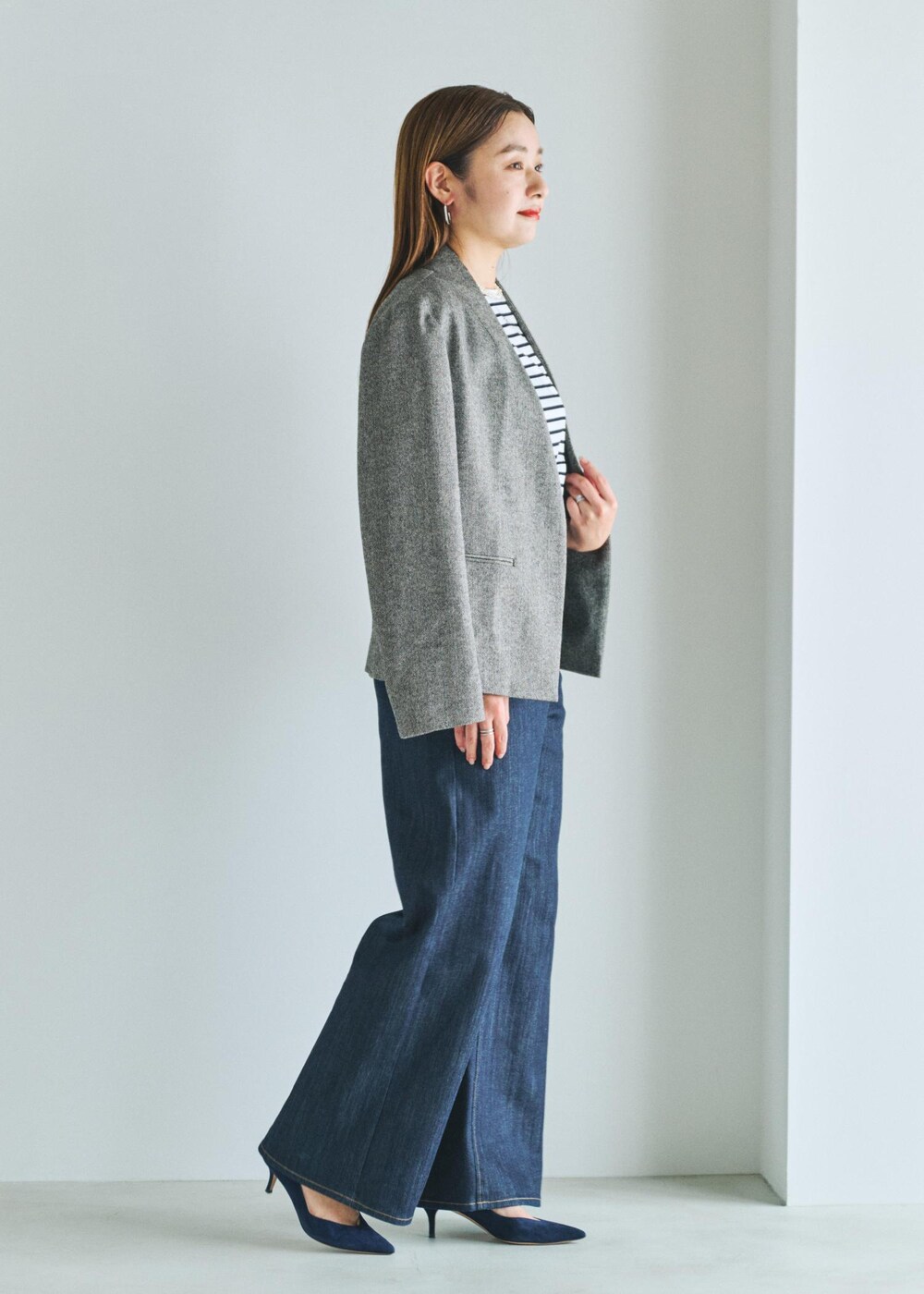 ブルー系のデニムパンツ、ホワイト系のTシャツ/カットソー、ブラック系のノーカラージャケットを着用したレディースの夏コーディネートの2枚目の写真