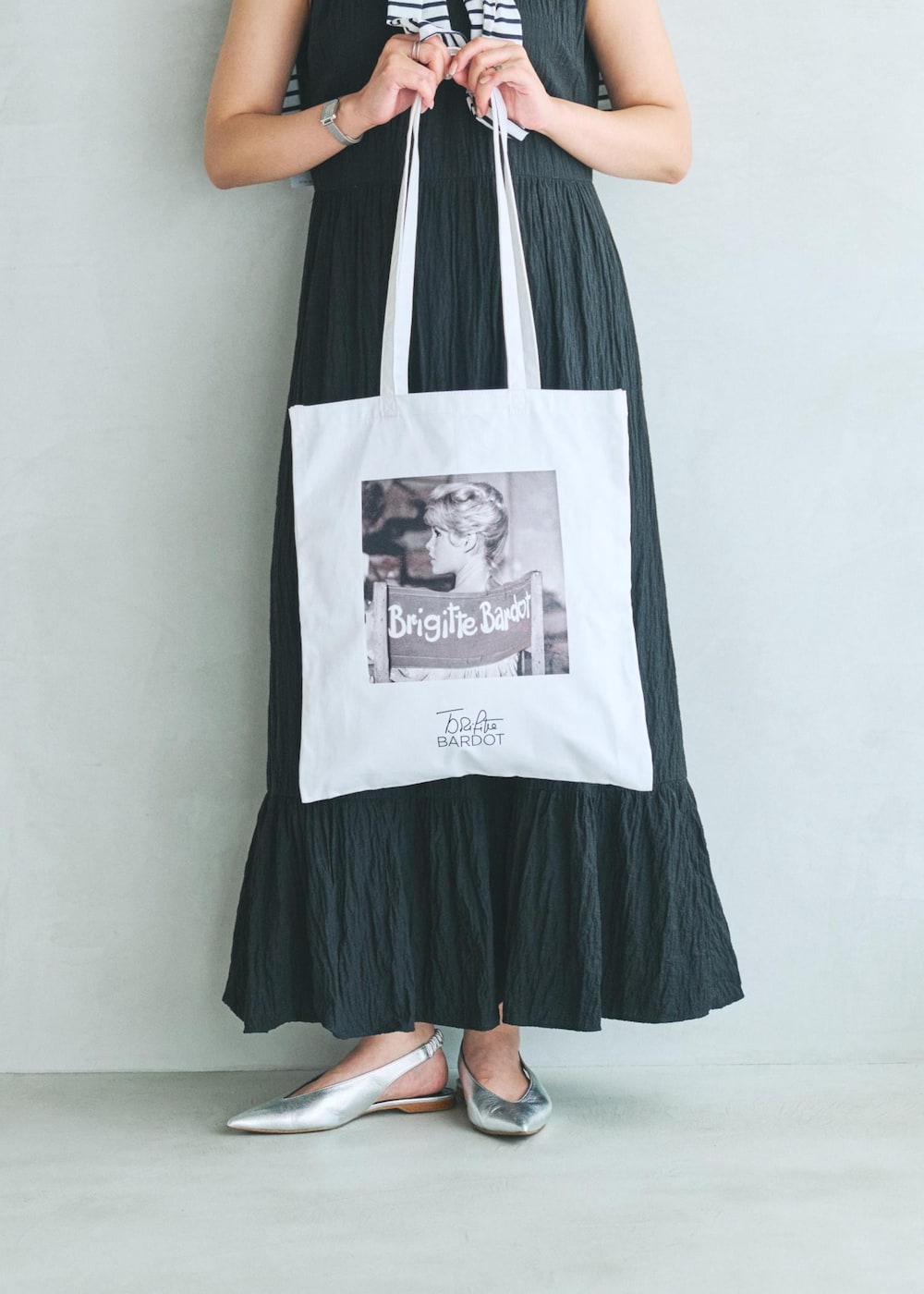 ブラック系のワンピース、ホワイト系のトートバッグを着用したレディースの夏コーディネートの3枚目の写真