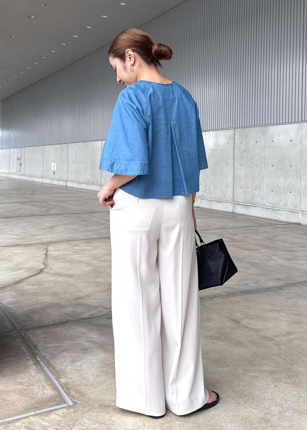 ベージュ系のその他パンツ、ブラック系のハンドバッグ、シルバー系のサンダルを着用したレディースの春コーディネートの3枚目の写真