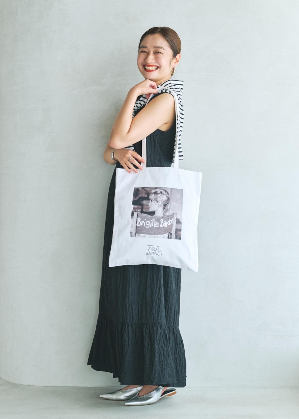 ブラック系のワンピース、ホワイト系のトートバッグを着用したレディースの夏コーディネートの2枚目の写真