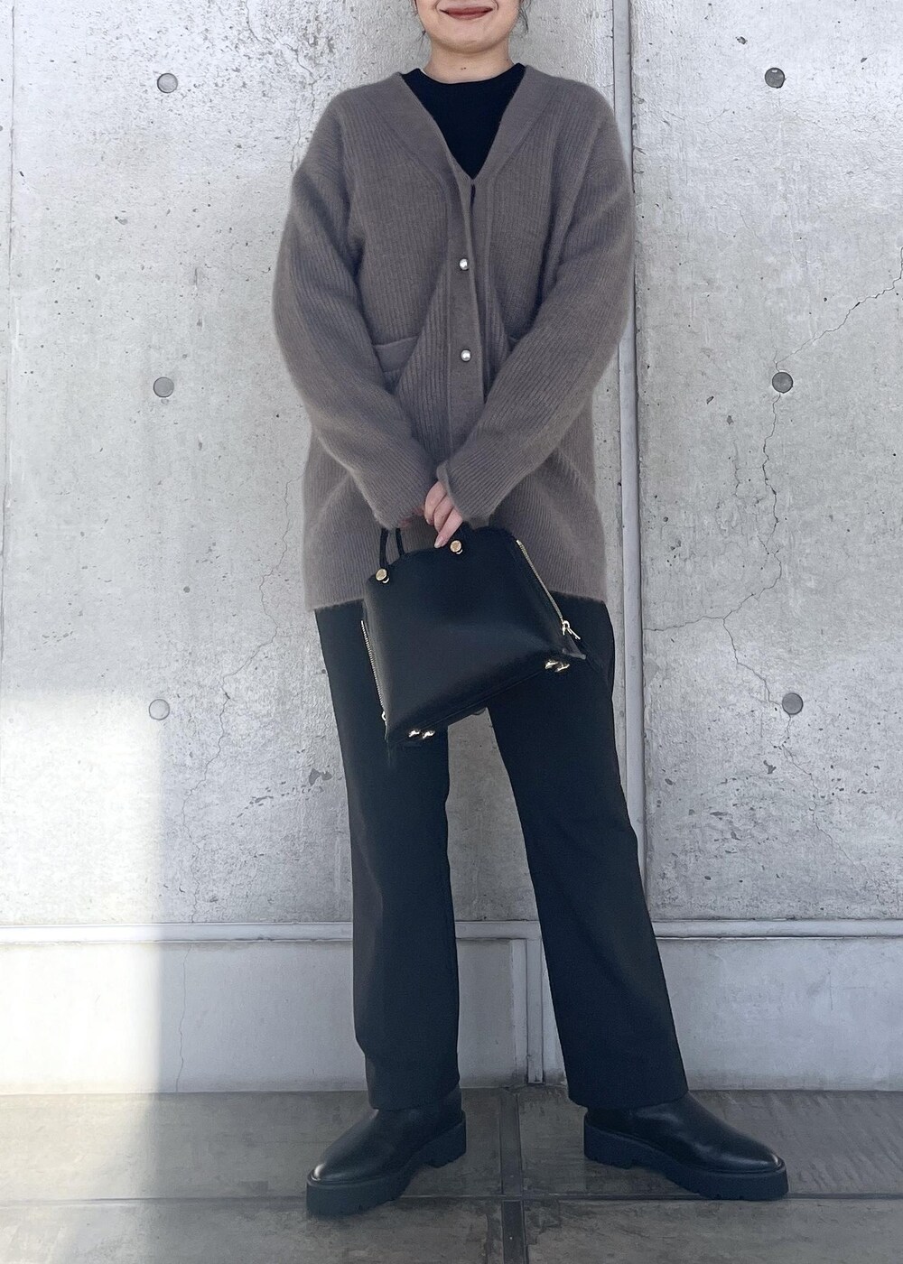 ブラック系のハンドバッグ、ブラック系のブーツ、ブラウン系のカーディガン/ボレロを着用したレディースの冬コーディネートの4枚目の写真