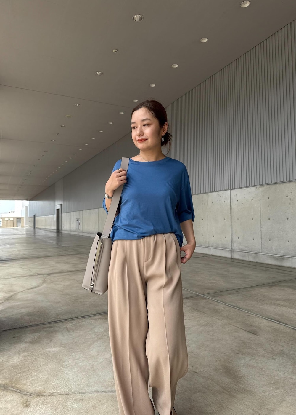 グレー系のショルダーバッグ、シルバー系のサンダル、ブルー系のTシャツ/カットソーを着用したレディースの夏コーディネートの4枚目の写真