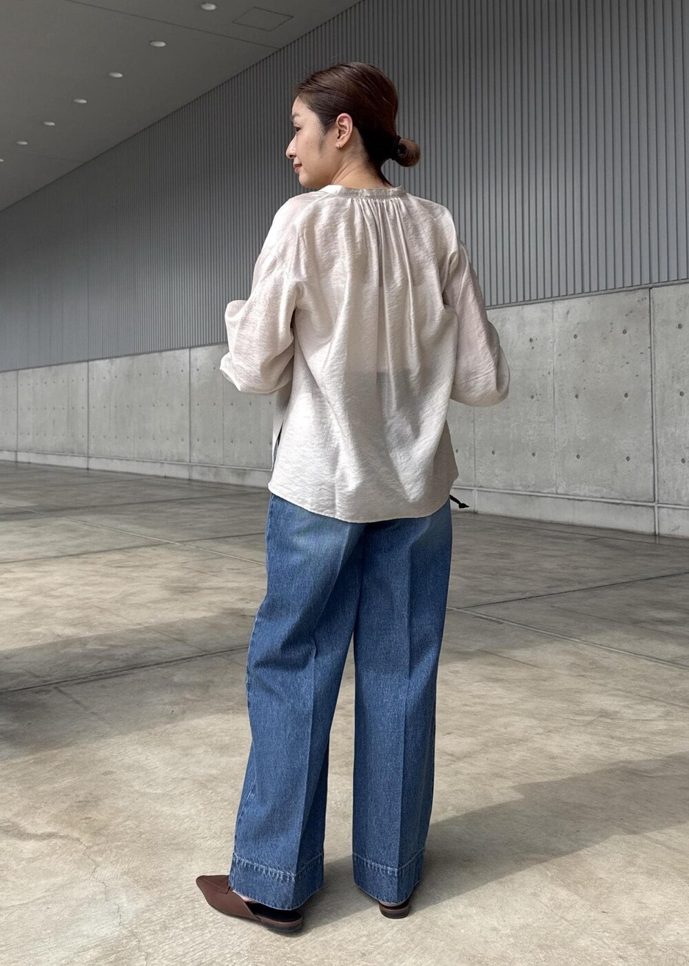 ブルー系のデニムパンツ、ブラック系のハンドバッグ、ベージュ系のシャツ/ブラウスを着用したレディースの春コーディネートの9枚目の写真