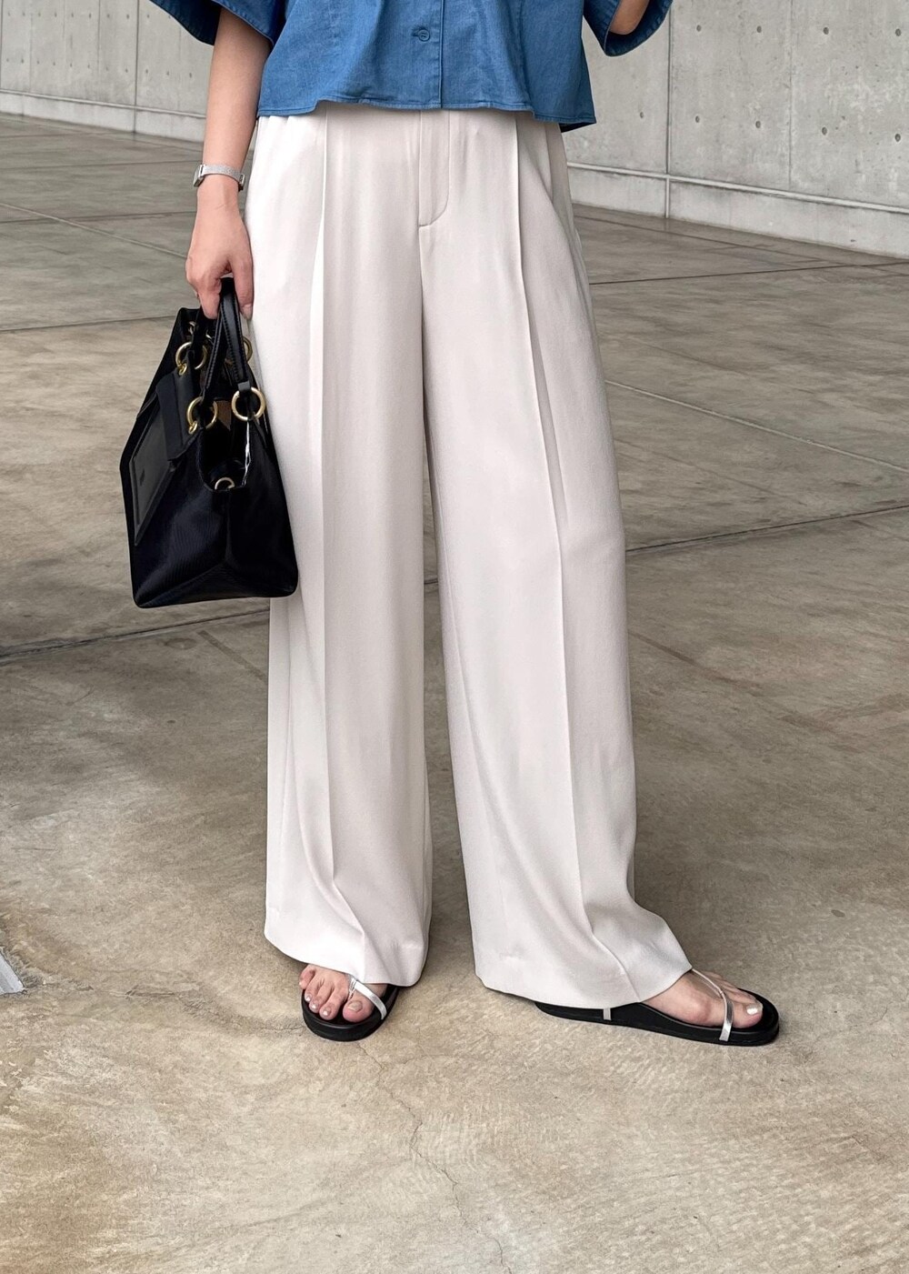 ベージュ系のその他パンツ、ブラック系のハンドバッグ、シルバー系のサンダルを着用したレディースの春コーディネートの6枚目の写真