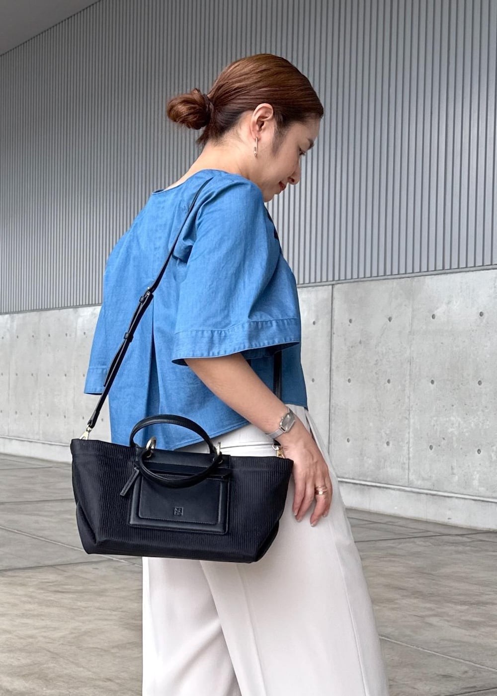 ベージュ系のその他パンツ、ブラック系のハンドバッグ、シルバー系のサンダルを着用したレディースの春コーディネートの7枚目の写真