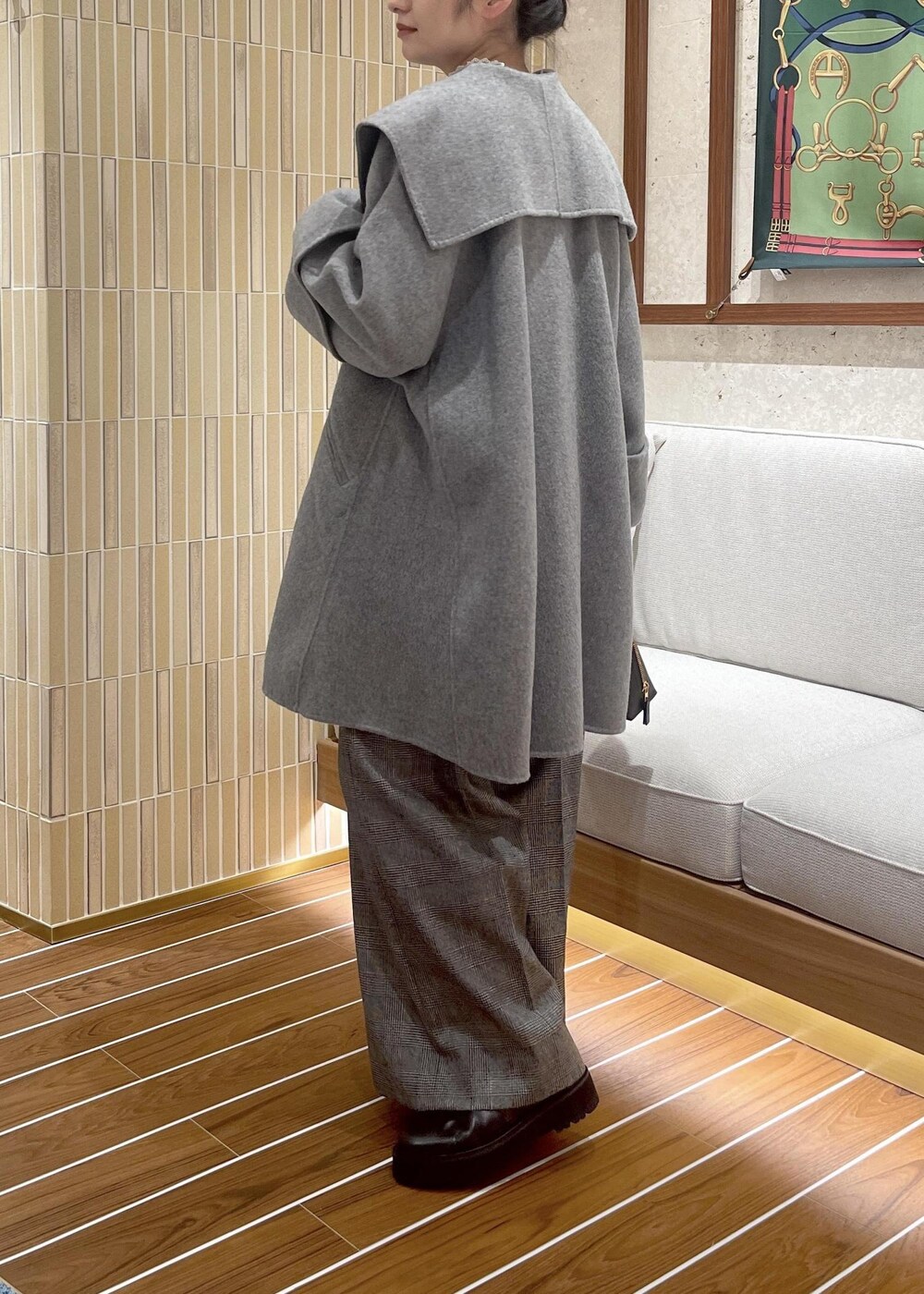 ブラウン系のハンドバッグ、グレー系のその他アウター、ブラック系のブーツを着用したレディースの秋コーディネートの5枚目の写真