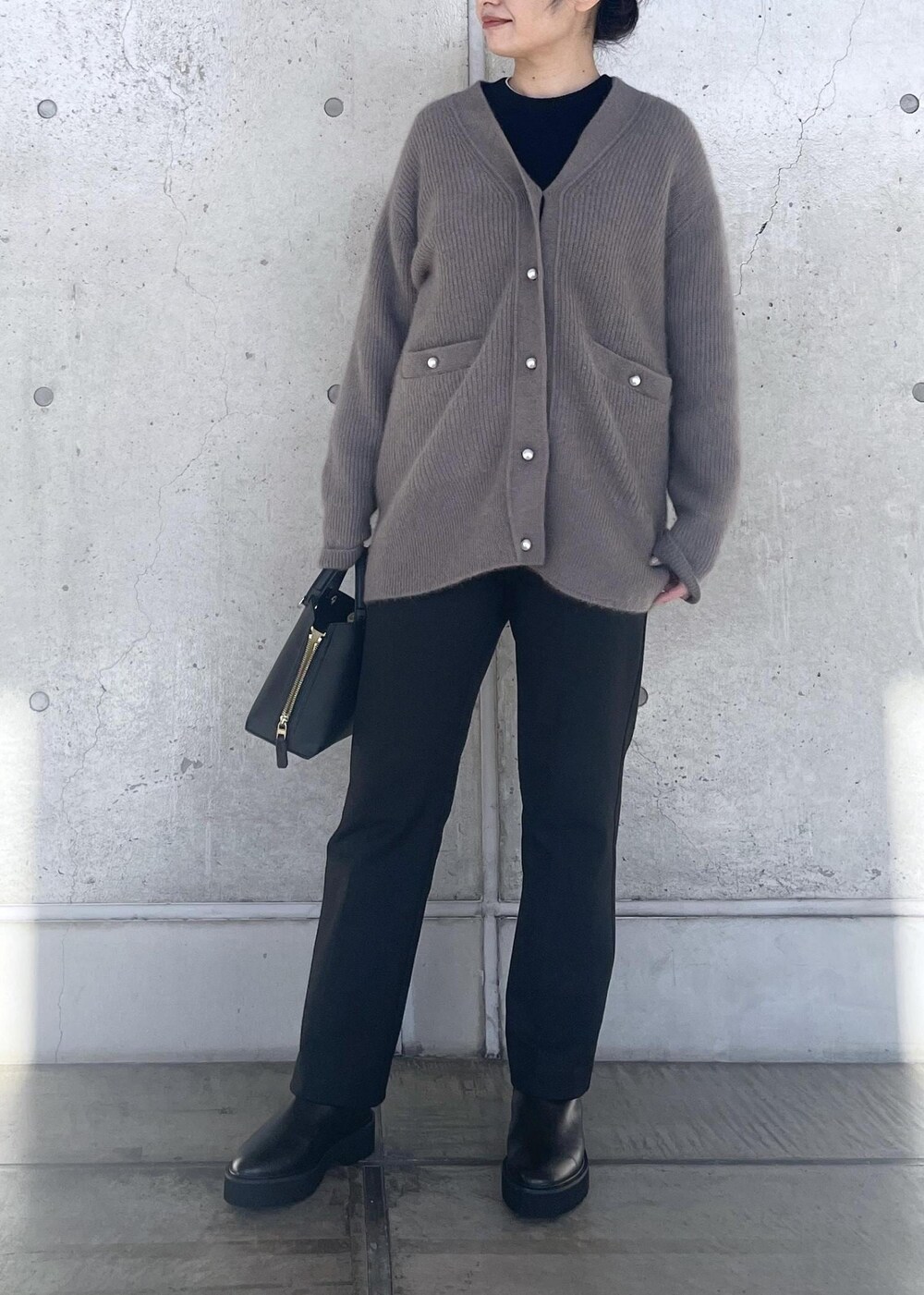 ブラック系のハンドバッグ、ブラック系のブーツ、ブラウン系のカーディガン/ボレロを着用したレディースの冬コーディネートの5枚目の写真