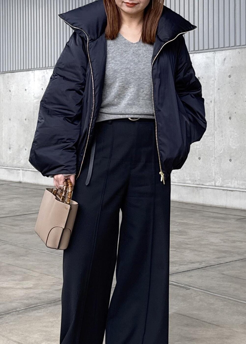 ブルー系のダウンジャケット/コート、グレー系のニット/セーター、ブラック系のその他パンツを着用したレディースの冬コーディネートの5枚目の写真