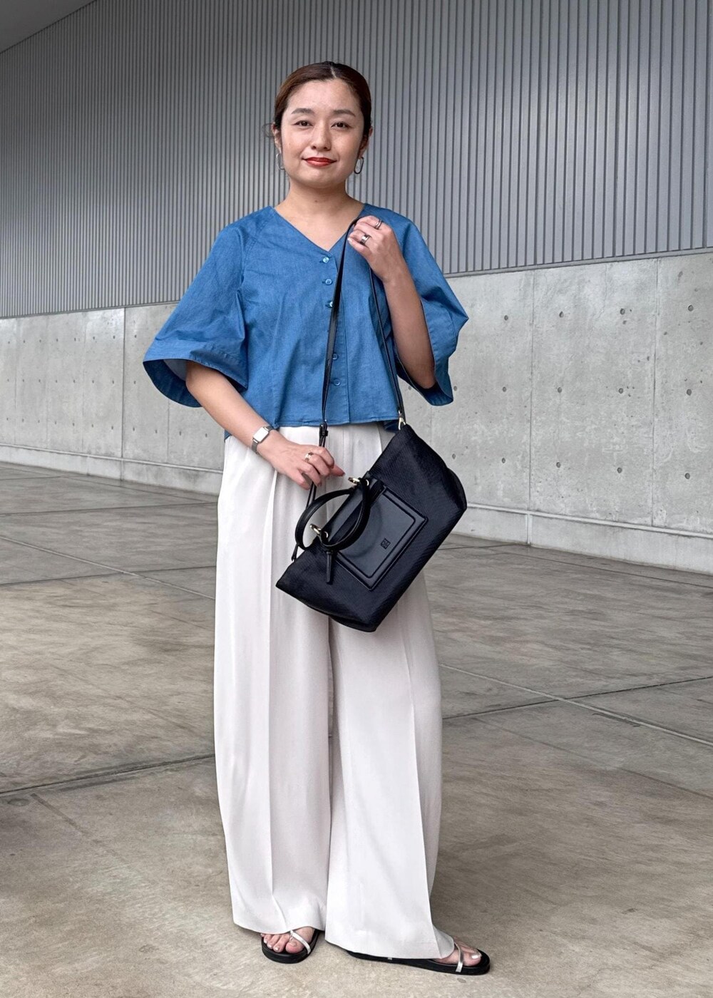 ベージュ系のその他パンツ、ブラック系のハンドバッグ、シルバー系のサンダルを着用したレディースの春コーディネートの2枚目の写真