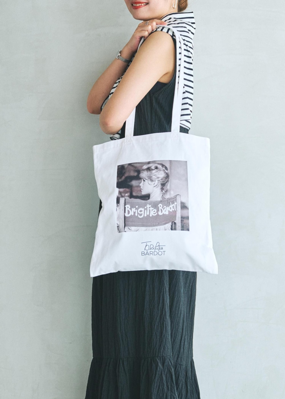 ブラック系のワンピース、ホワイト系のトートバッグを着用したレディースの夏コーディネートの7枚目の写真