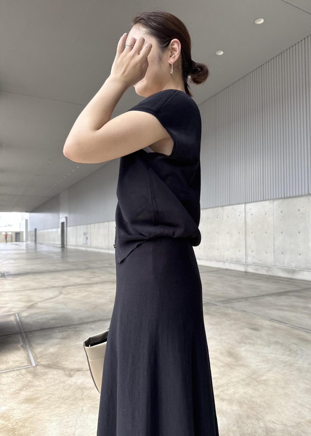 ベージュ系のトートバッグ、ブラック系のサンダル、ブラック系のニット/セーターを着用したレディースの夏コーディネートの6枚目の写真
