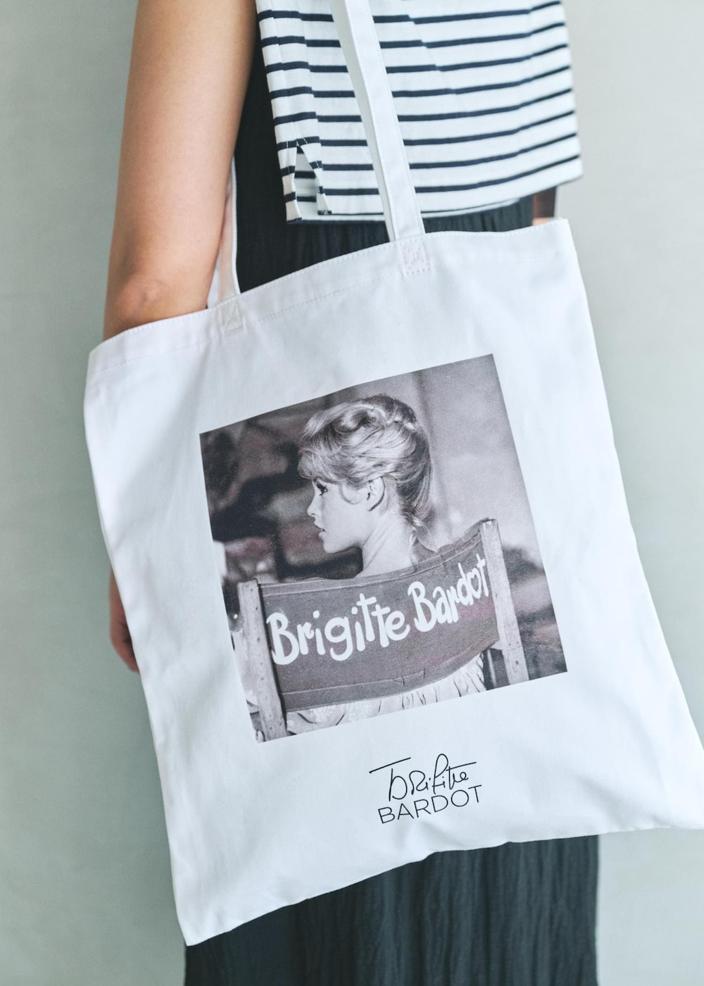 ブラック系のワンピース、ホワイト系のトートバッグを着用したレディースの夏コーディネートの6枚目の写真