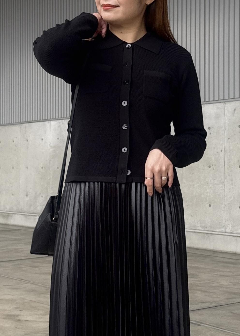 ブラック系のスカート、ブラック系のショルダーバッグ、ベージュ系のトレンチコートを着用したレディースの春コーディネートの5枚目の写真