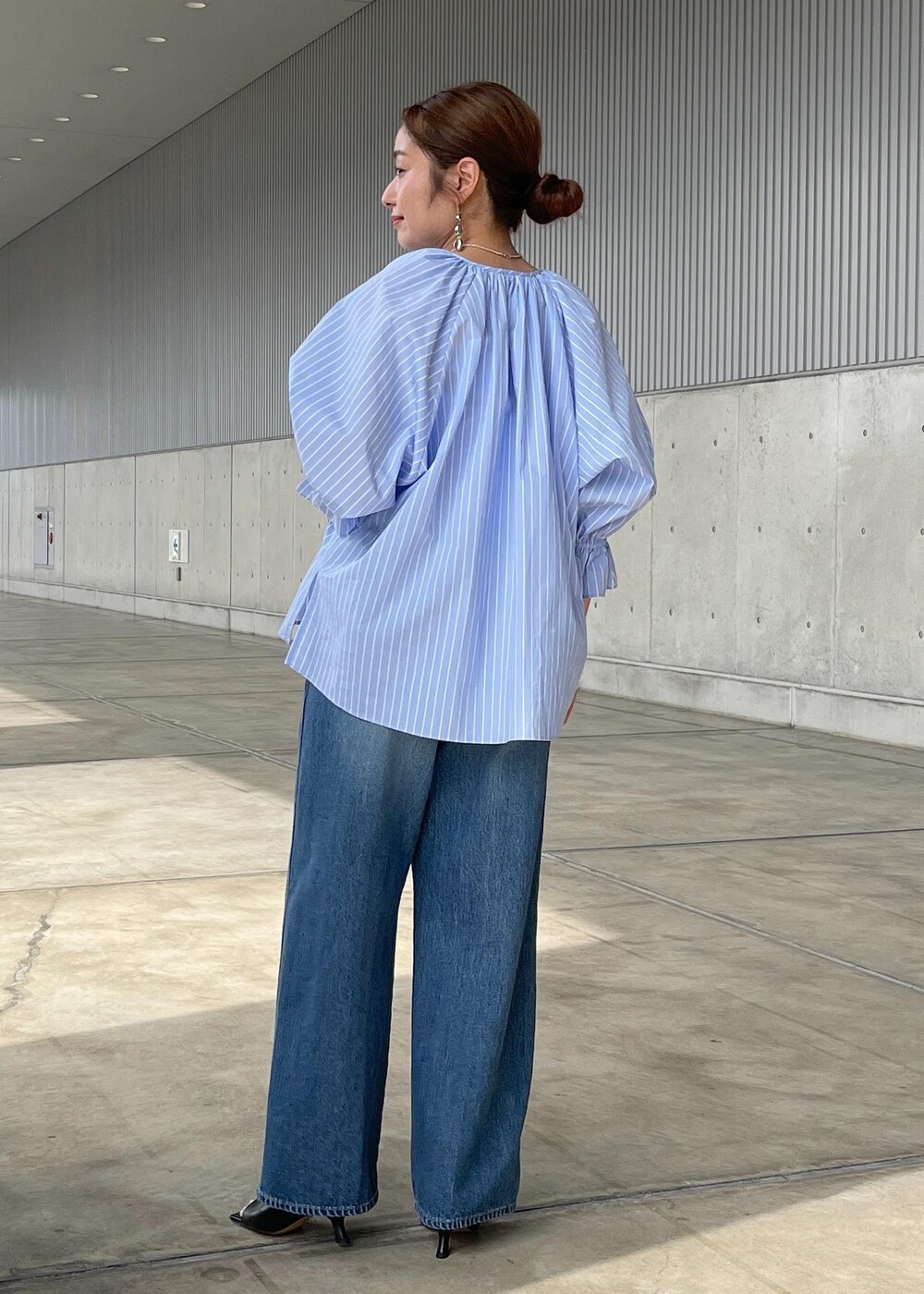 ブルー系のシャツ/ブラウス、ブルー系のデニムパンツ、ブラック系のサンダルを着用したレディースの春コーディネートの4枚目の写真