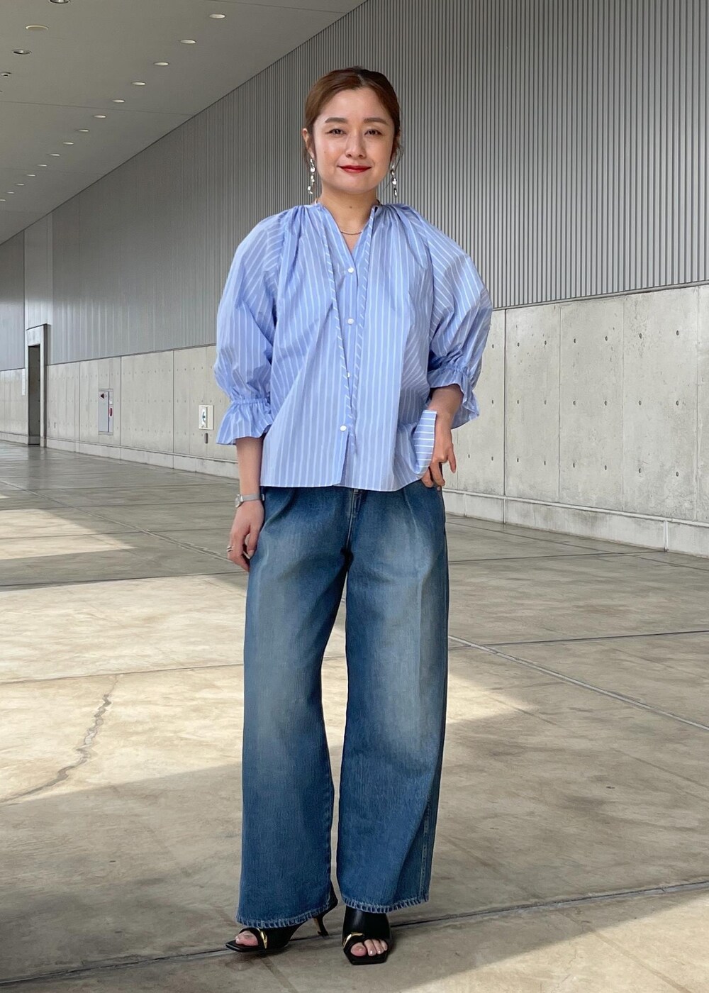 ブルー系のシャツ/ブラウス、ブルー系のデニムパンツ、ブラック系のサンダルを着用したレディースの春コーディネートの2枚目の写真