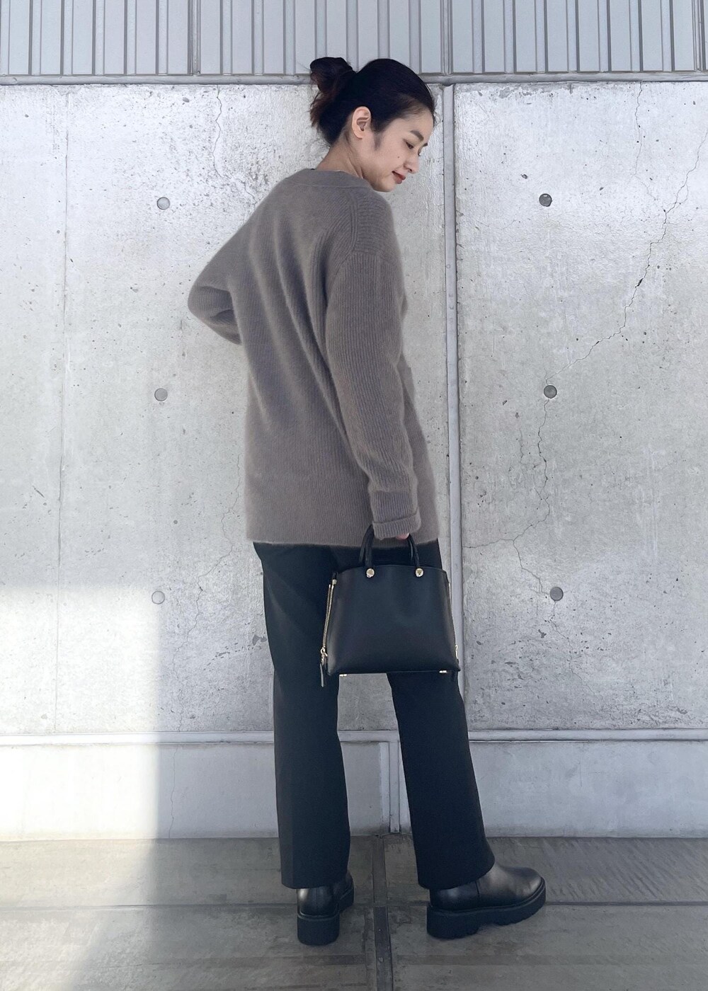 ブラック系のハンドバッグ、ブラック系のブーツ、ブラウン系のカーディガン/ボレロを着用したレディースの冬コーディネートの2枚目の写真