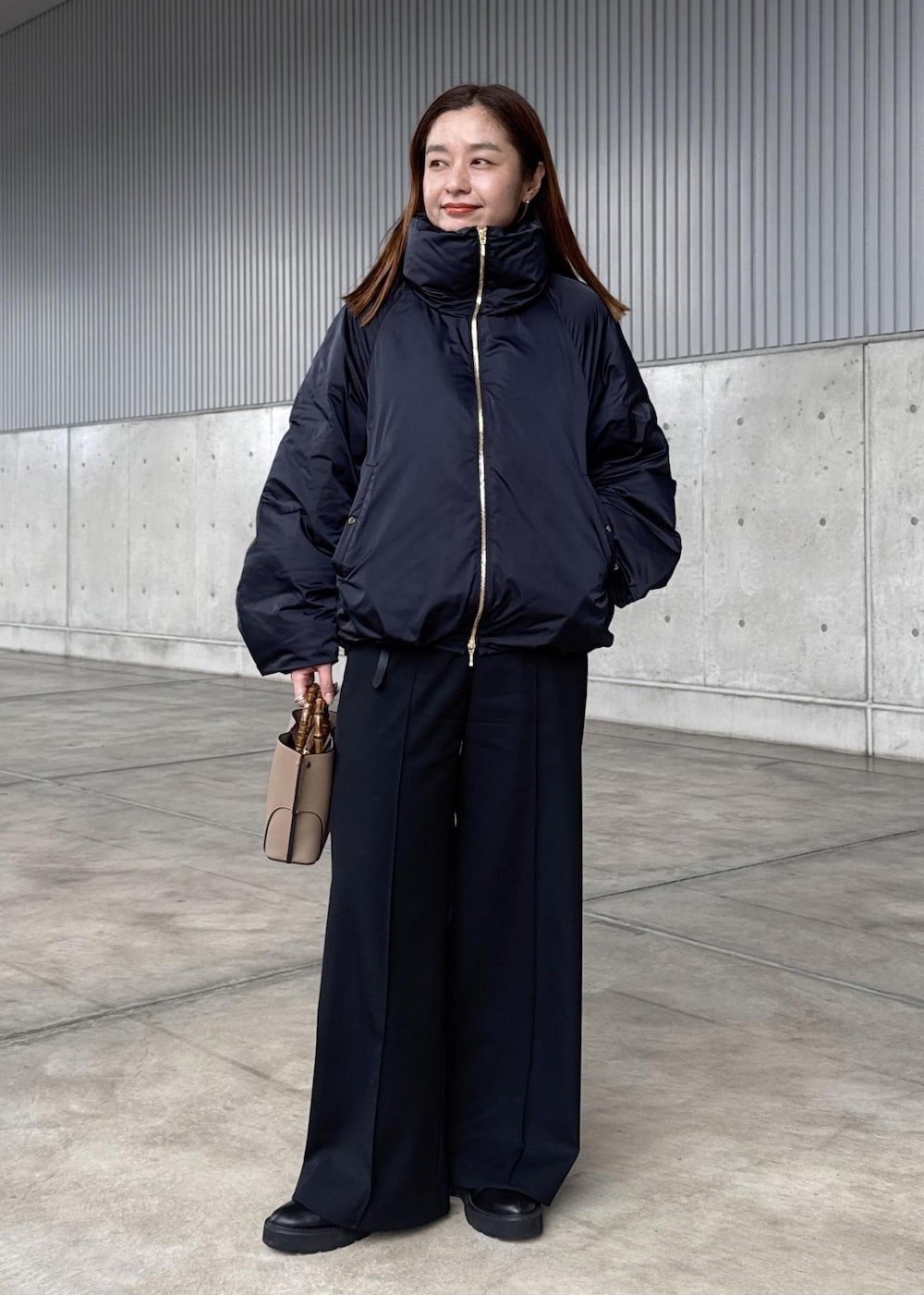 ブルー系のダウンジャケット/コート、グレー系のニット/セーター、ブラック系のその他パンツを着用したレディースの冬コーディネートの3枚目の写真