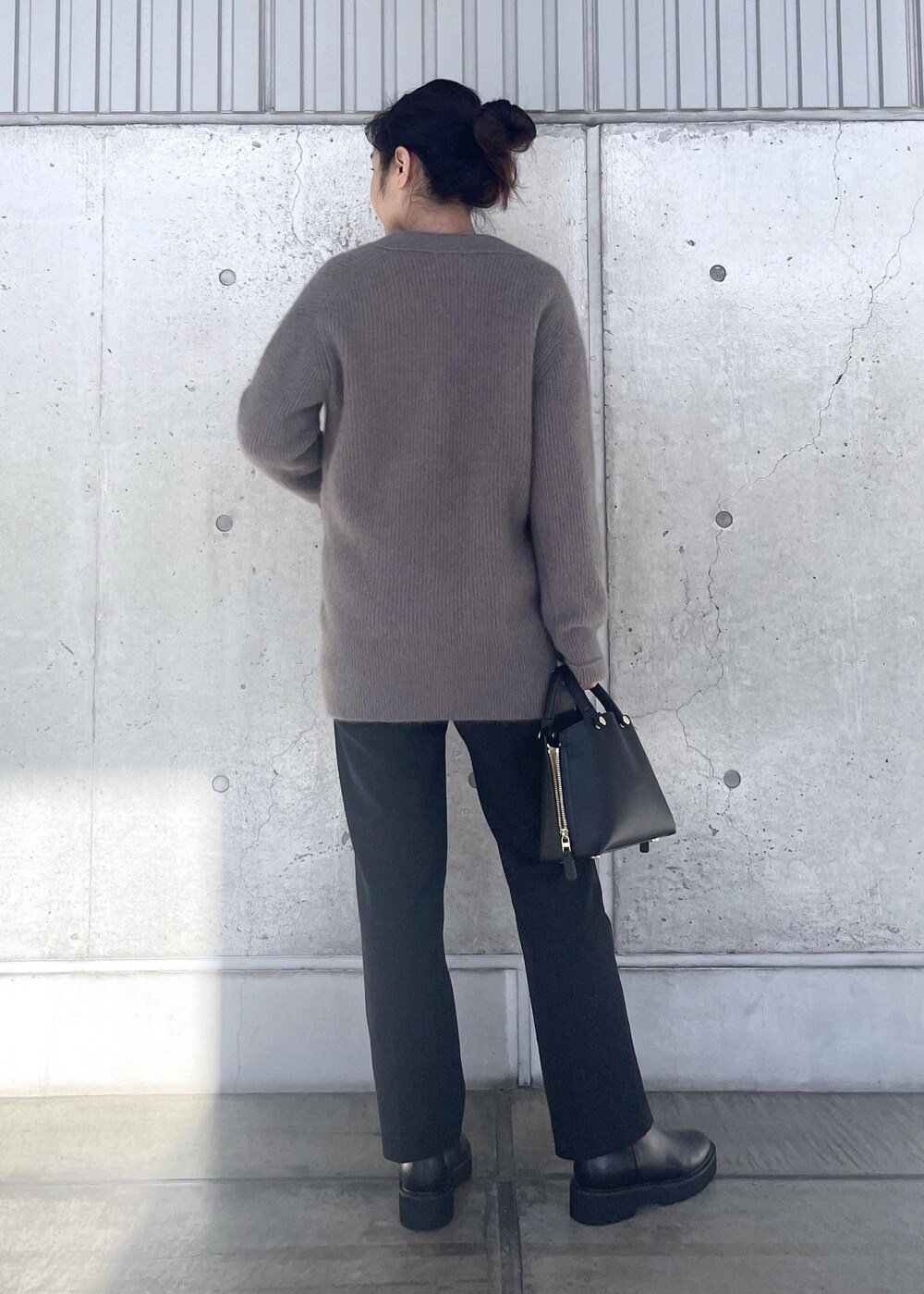 ブラック系のハンドバッグ、ブラック系のブーツ、ブラウン系のカーディガン/ボレロを着用したレディースの冬コーディネートの3枚目の写真