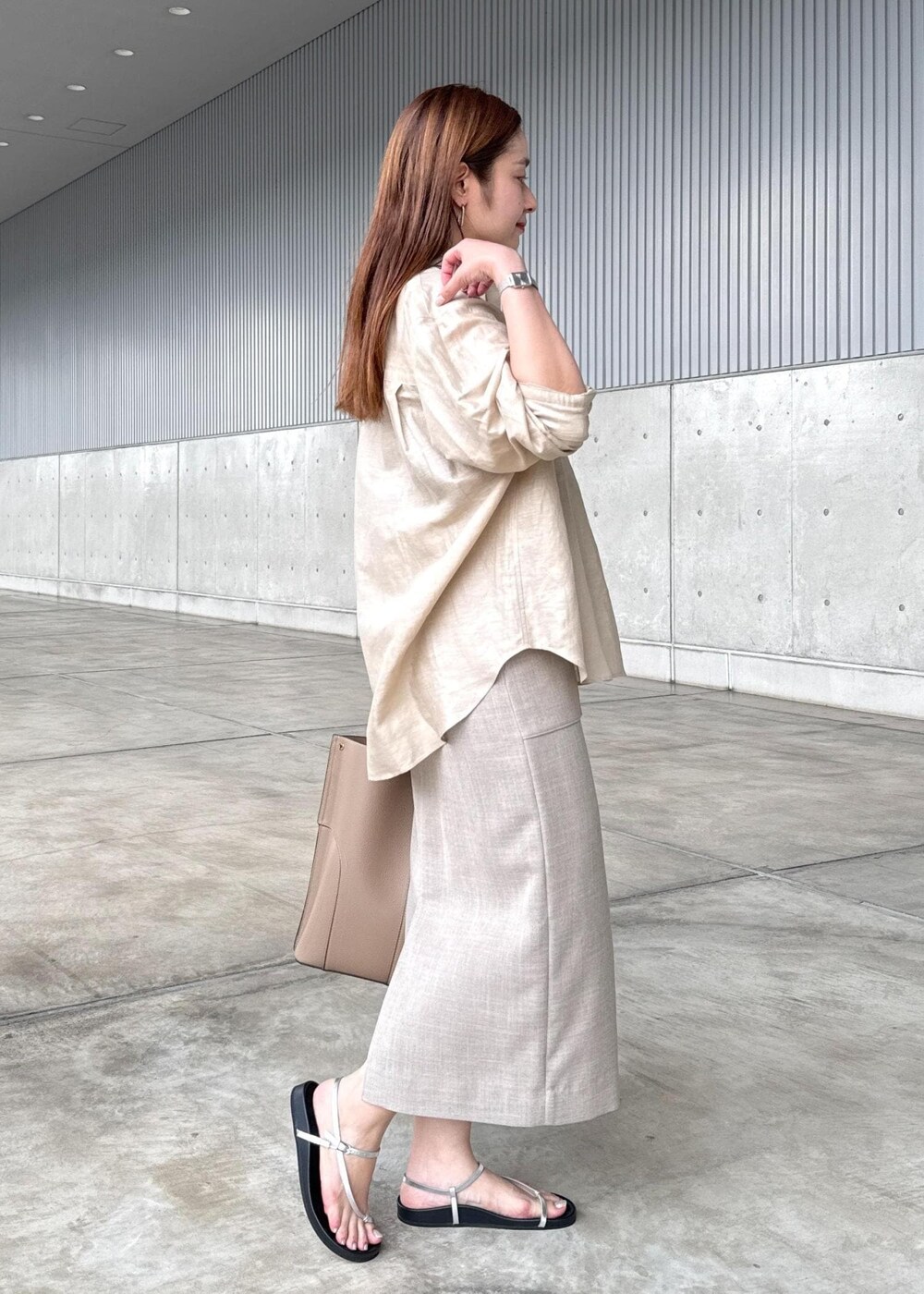 ベージュ系のトートバッグ、シルバー系のサンダル、ベージュ系のシャツ/ブラウスを着用したレディースの秋コーディネートの2枚目の写真