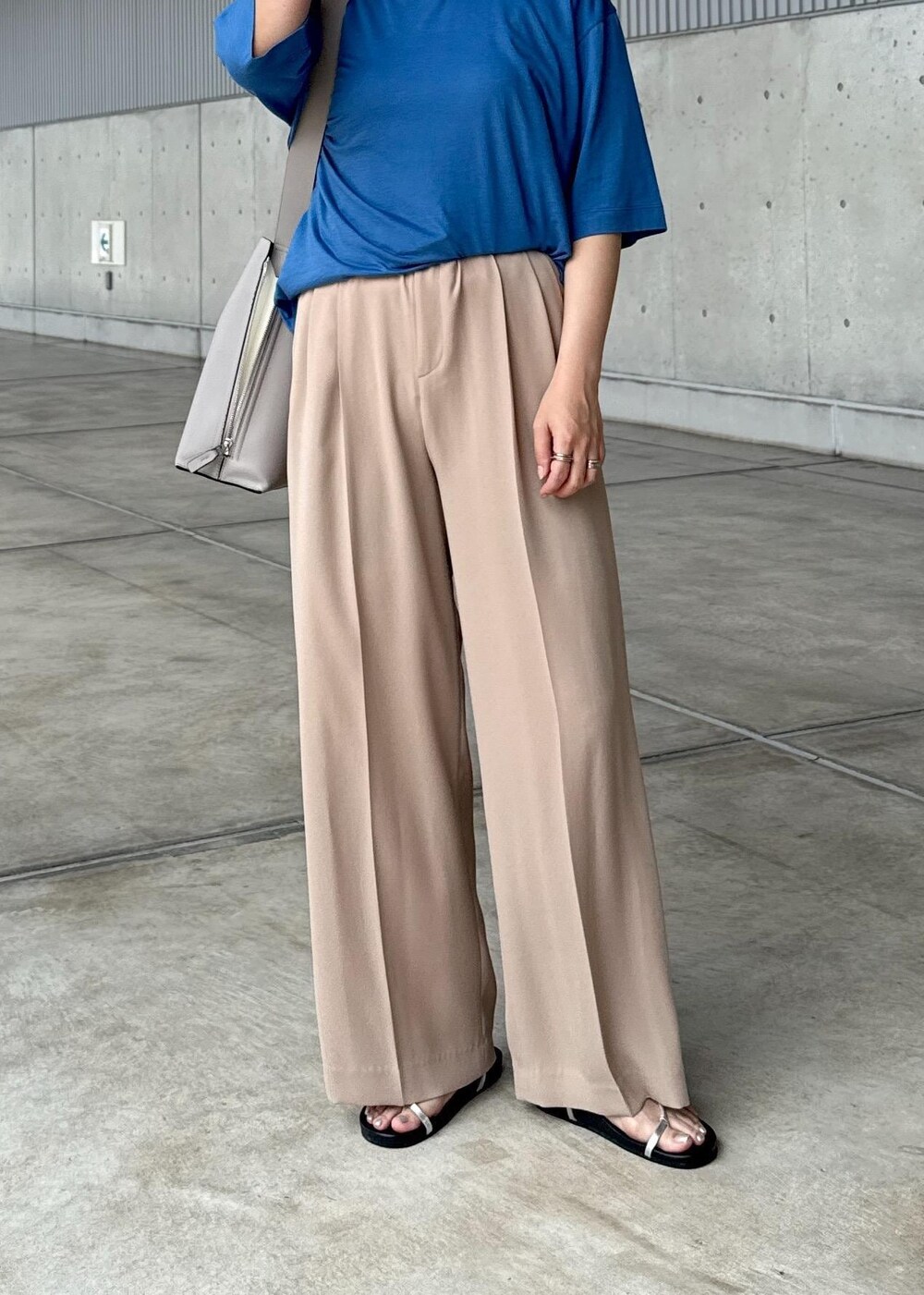 グレー系のショルダーバッグ、シルバー系のサンダル、ブルー系のTシャツ/カットソーを着用したレディースの夏コーディネートの6枚目の写真