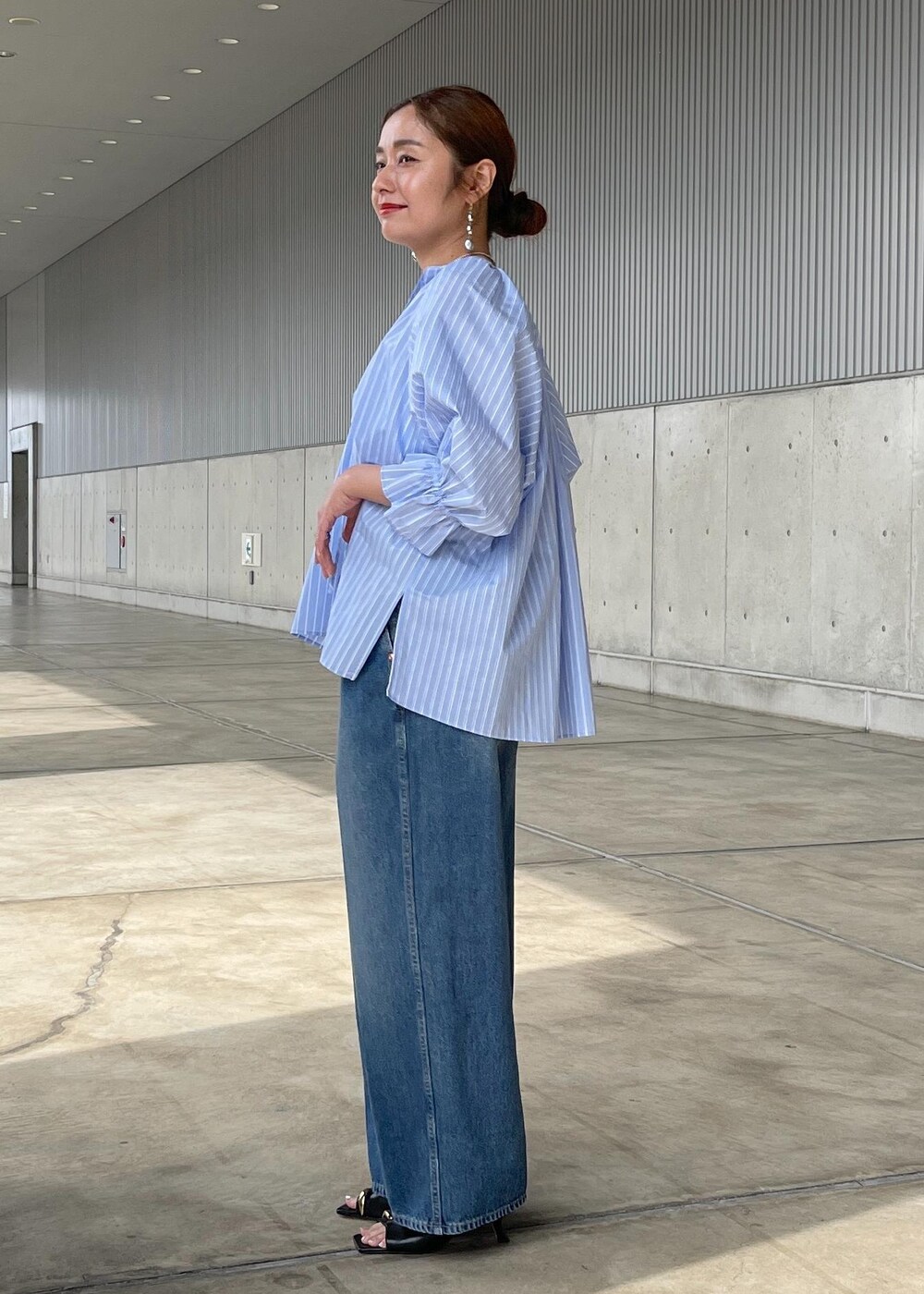 ブルー系のシャツ/ブラウス、ブルー系のデニムパンツ、ブラック系のサンダルを着用したレディースの春コーディネートの3枚目の写真
