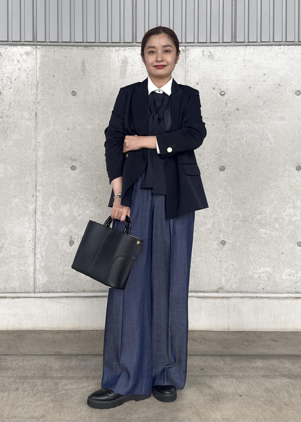 ブラック系のハンドバッグ、ブルー系のその他パンツ、ブルー系のテーラードジャケットを着用したレディースの秋コーディネートの2枚目の写真
