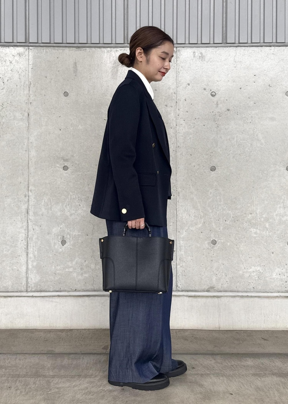 ブラック系のハンドバッグ、ブルー系のその他パンツ、ブルー系のテーラードジャケットを着用したレディースの秋コーディネートの3枚目の写真