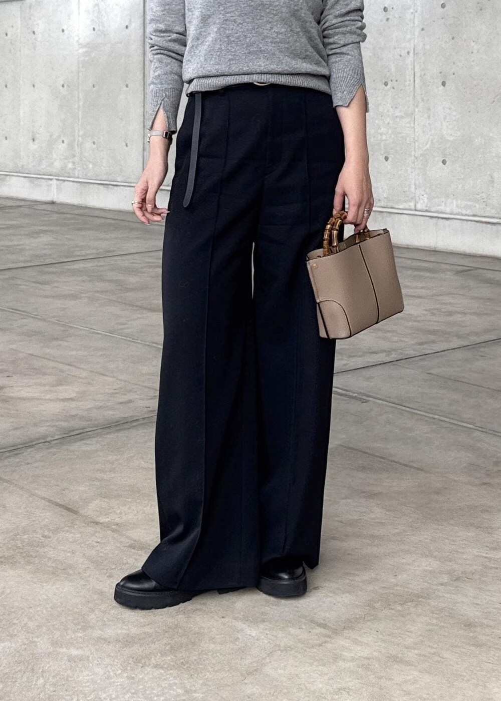 ブルー系のダウンジャケット/コート、グレー系のニット/セーター、ブラック系のその他パンツを着用したレディースの冬コーディネートの9枚目の写真