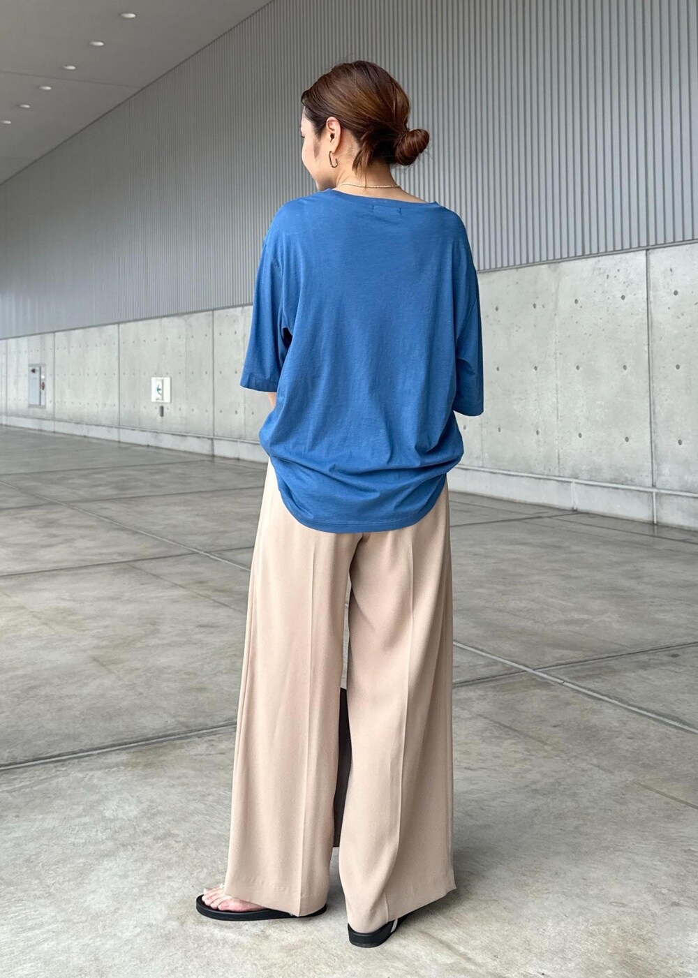 グレー系のショルダーバッグ、シルバー系のサンダル、ブルー系のTシャツ/カットソーを着用したレディースの夏コーディネートの3枚目の写真