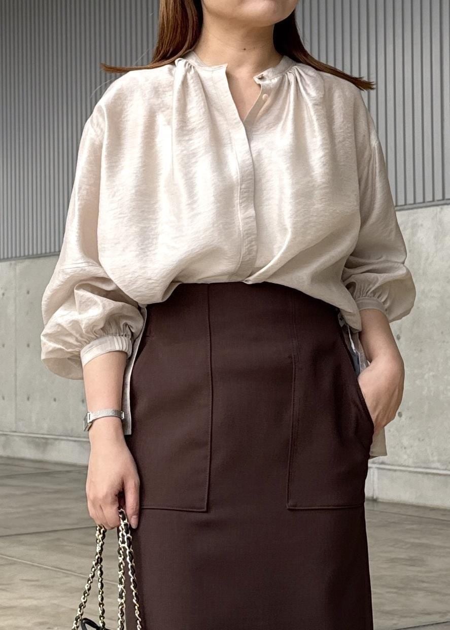 ブラック系のハンドバッグ、ブラウン系のスカート、ベージュ系のシャツ/ブラウスを着用したレディースの春コーディネートの5枚目の写真