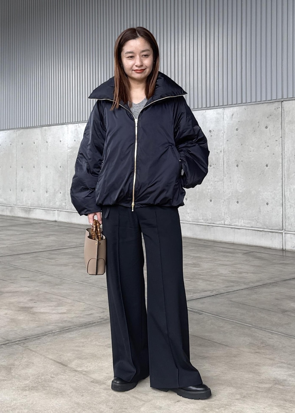 ブルー系のダウンジャケット/コート、グレー系のニット/セーター、ブラック系のその他パンツを着用したレディースの冬コーディネートの2枚目の写真