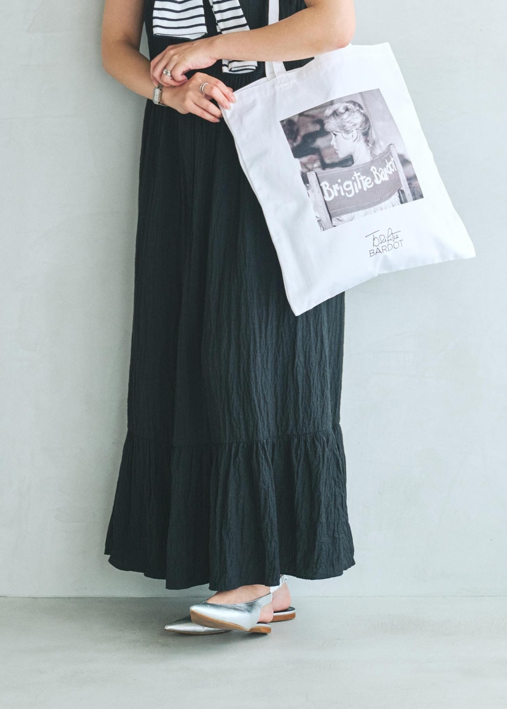 ブラック系のワンピース、ホワイト系のトートバッグを着用したレディースの夏コーディネートの4枚目の写真