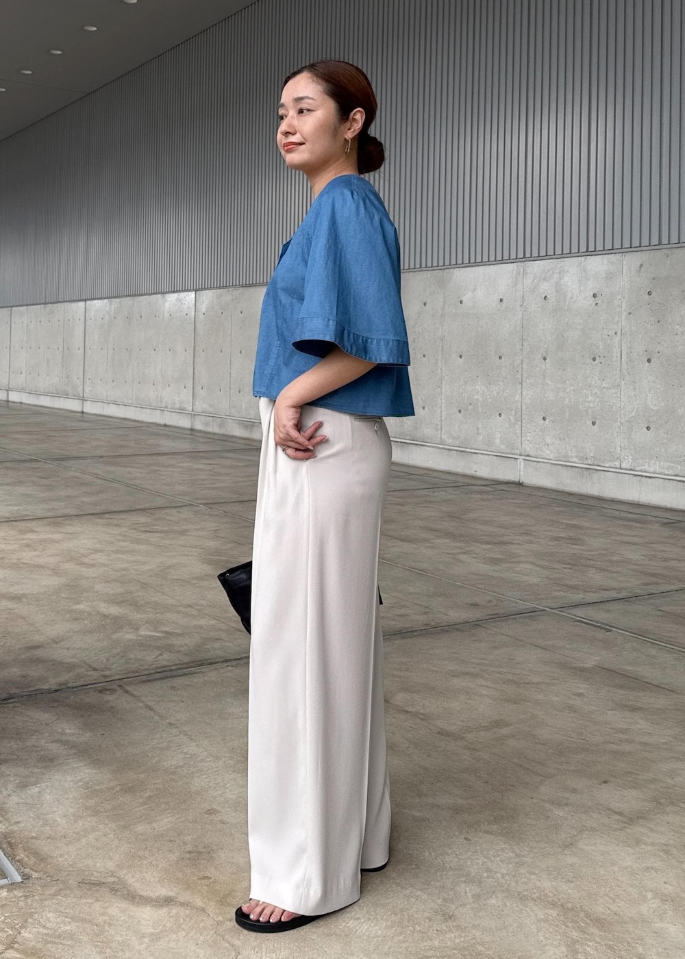 ベージュ系のその他パンツ、ブラック系のハンドバッグ、シルバー系のサンダルを着用したレディースの春コーディネートの4枚目の写真