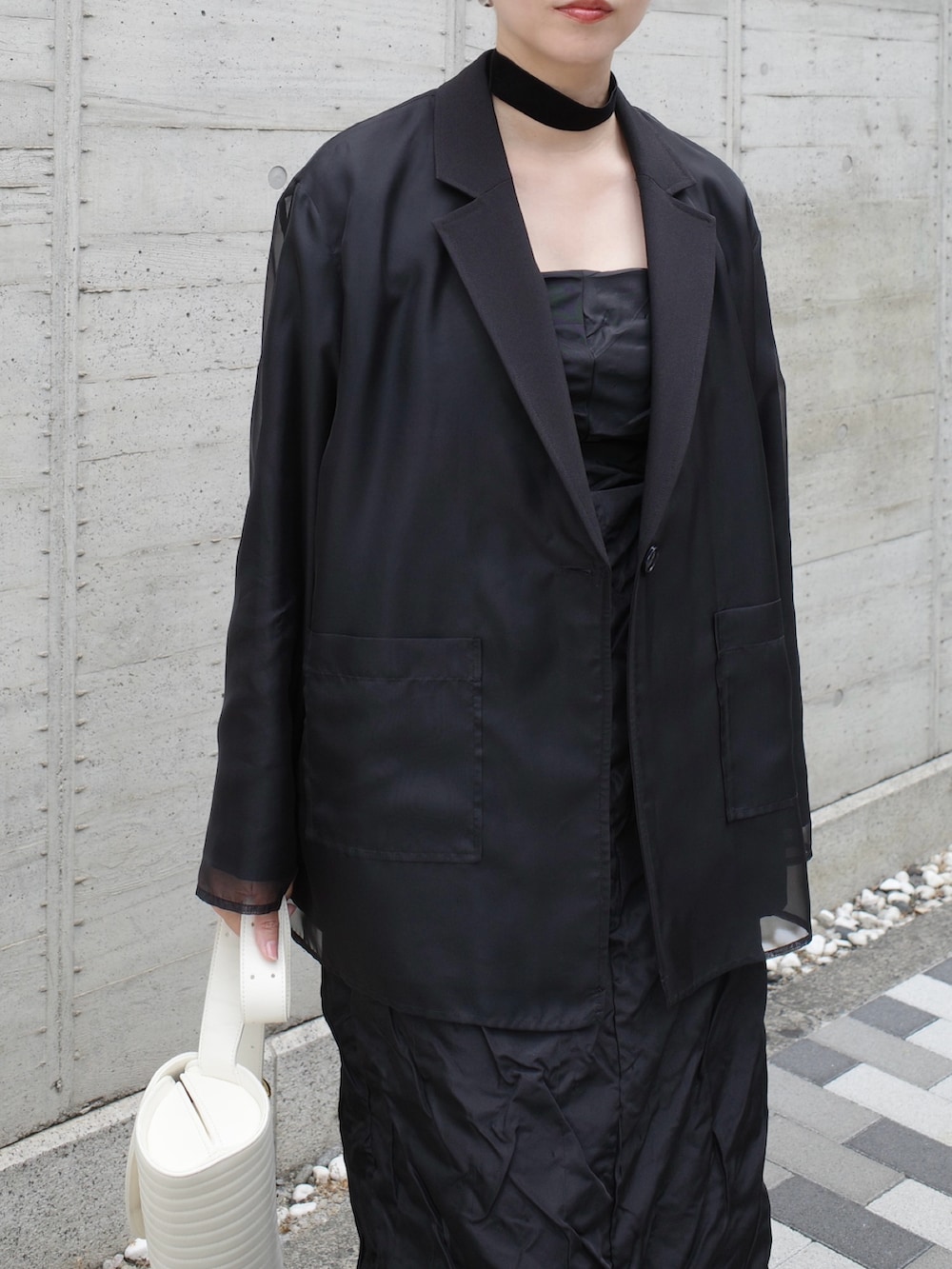 ブラック系のその他アウター、ブラック系のワンピース、ホワイト系のバッグを着用したレディースの秋コーディネートの3枚目の写真