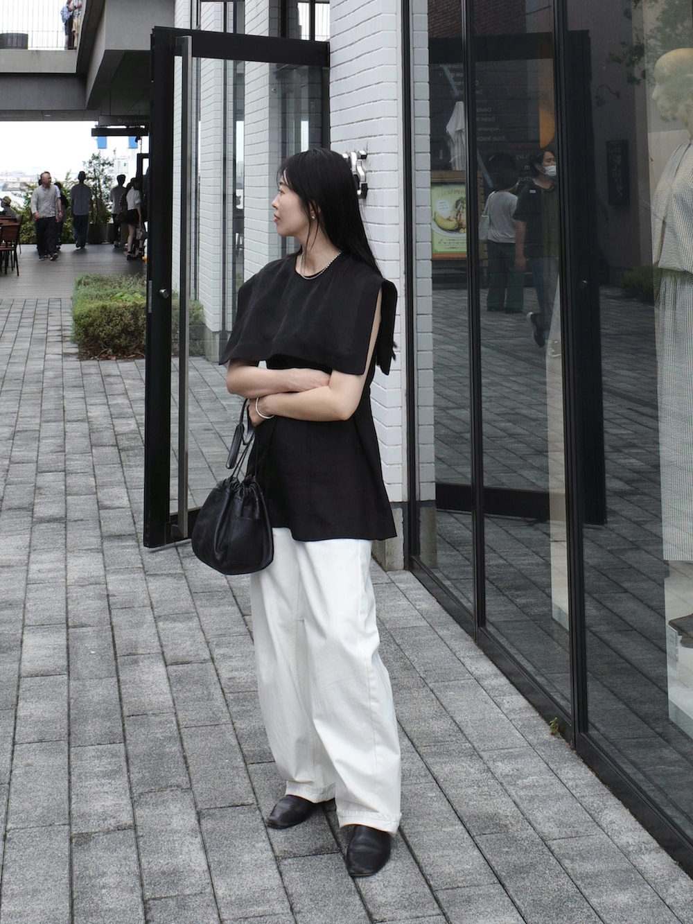 ホワイト系のショルダーバッグ、ホワイト系のデニムパンツ、ブラック系のシャツ/ブラウスを着用したレディースの秋コーディネートの3枚目の写真