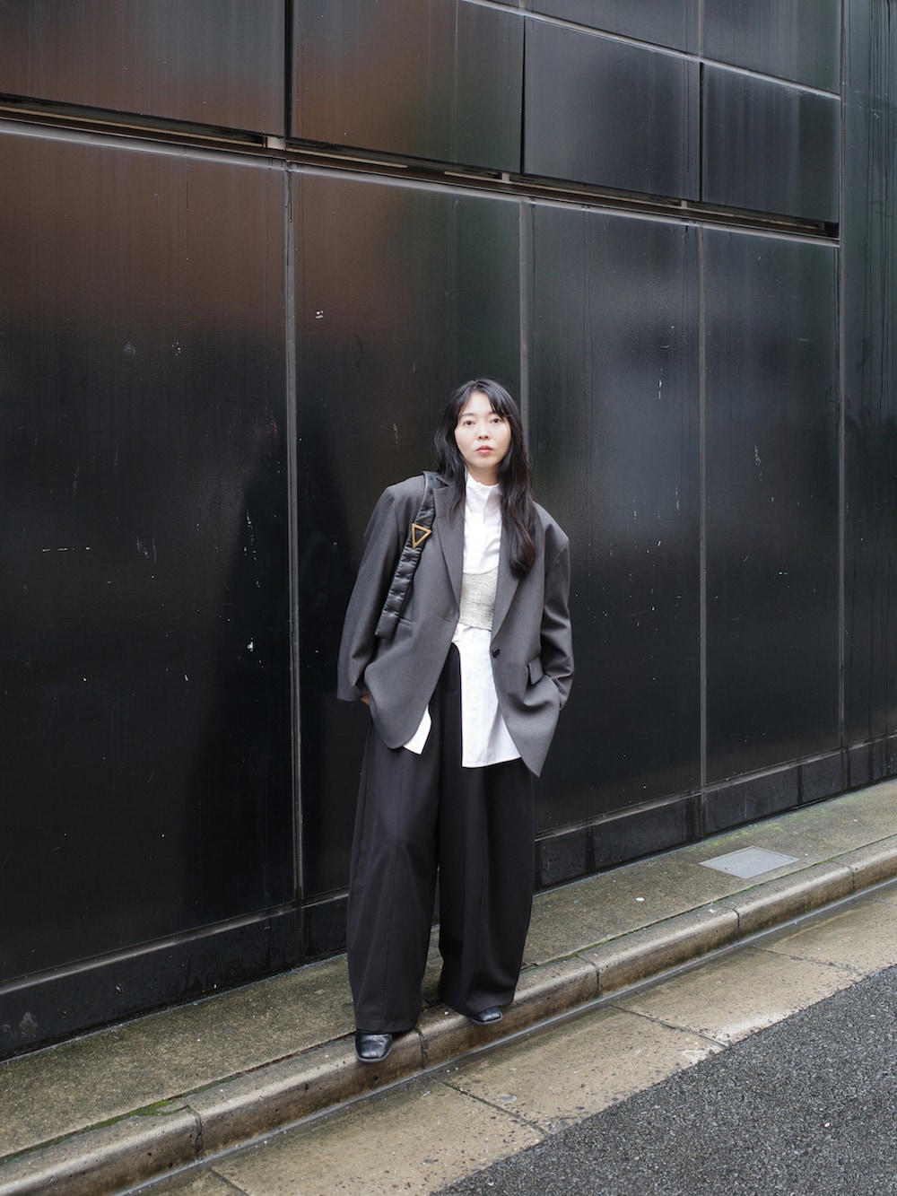 ホワイト系のシャツ/ブラウス、グレー系のテーラードジャケット、ブラック系のバッグを着用したレディースの秋コーディネートの2枚目の写真