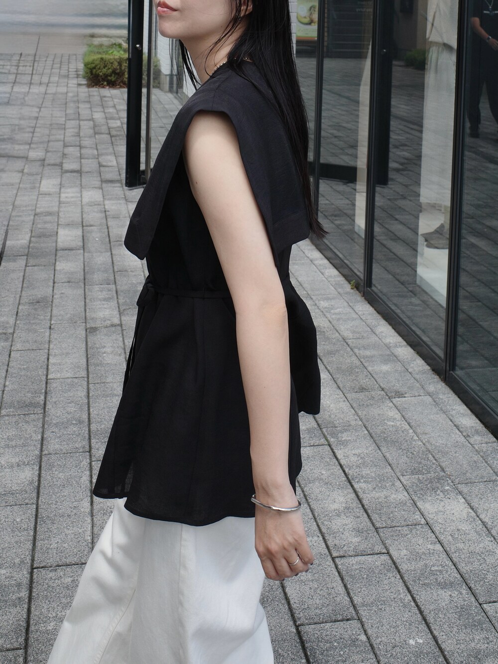 ホワイト系のショルダーバッグ、ホワイト系のデニムパンツ、ブラック系のシャツ/ブラウスを着用したレディースの秋コーディネートの5枚目の写真