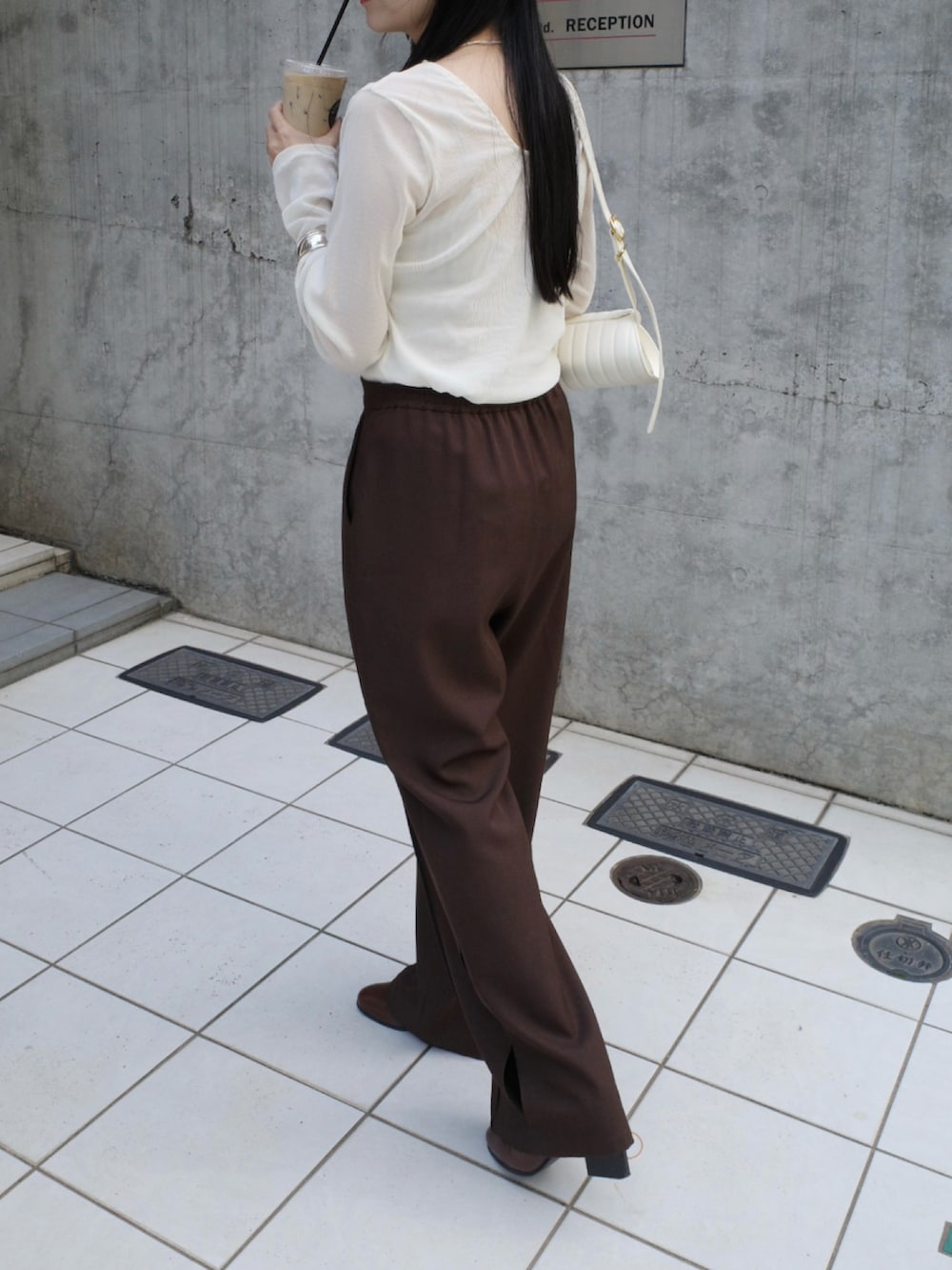 ホワイト系のTシャツ/カットソー、ブラウン系のその他パンツ、ホワイト系のバッグを着用したレディースの秋コーディネートの3枚目の写真