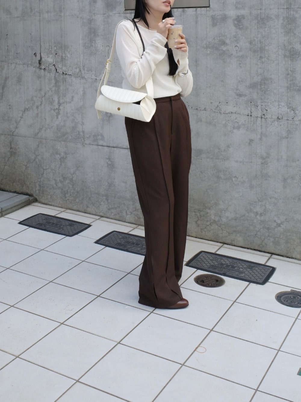 ホワイト系のTシャツ/カットソー、ブラウン系のその他パンツ、ホワイト系のバッグを着用したレディースの秋コーディネートの2枚目の写真