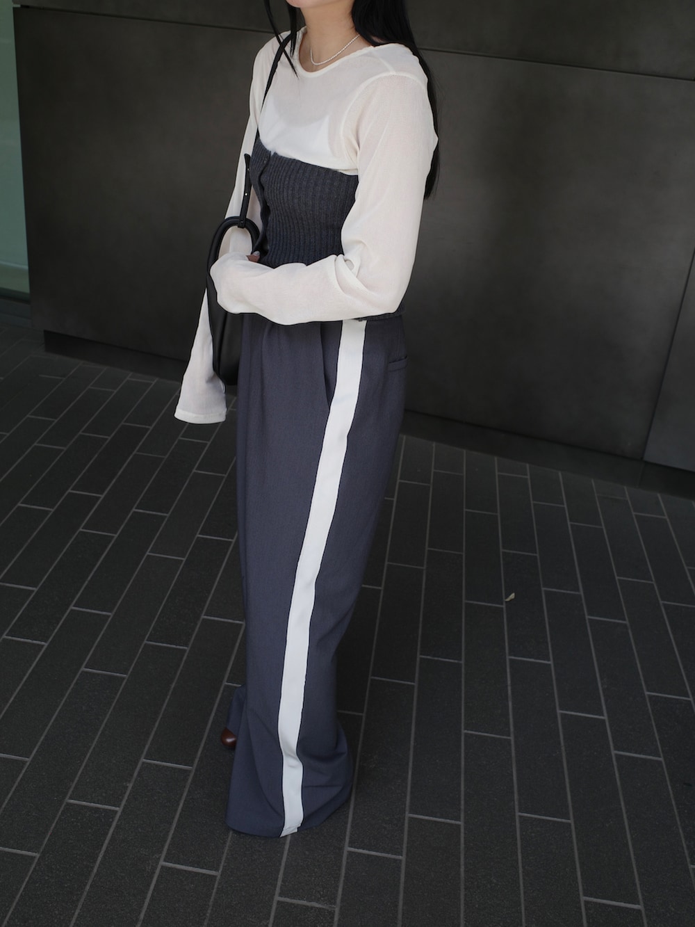 グレー系のその他パンツ、ホワイト系のTシャツ/カットソー、グレー系のニット/セーターを着用したレディースの秋コーディネートの3枚目の写真